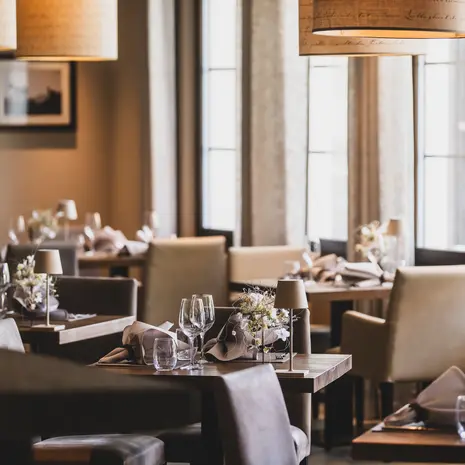 La Val Hotel & Spa: Ihr Hotel in Breil/Brigels Elegantes Restaurant mit gedeckten Tischen und warmem Licht
