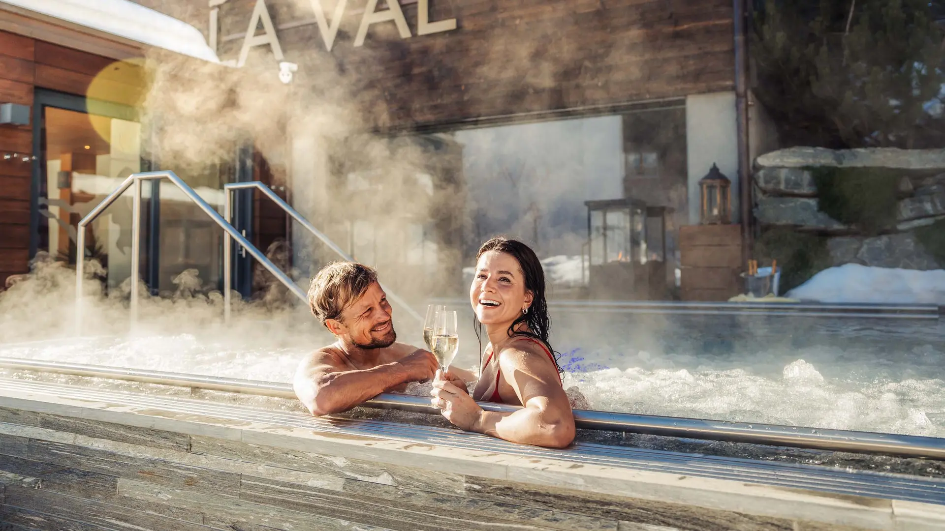 La Val Hotel & Spa: Ihr Hotel in Breil/Brigels Paar genießt Champagner in Außenwhirlpool mit Dampf im Spa-Resort
