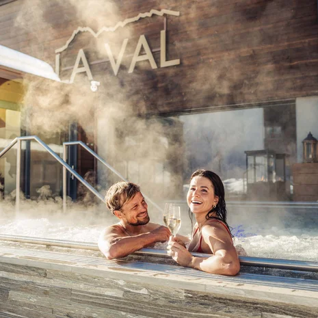 La Val Hotel & Spa: Ihr Hotel in Breil/Brigels Paar genießt Champagner in Außenwhirlpool mit Dampf im Spa-Resort